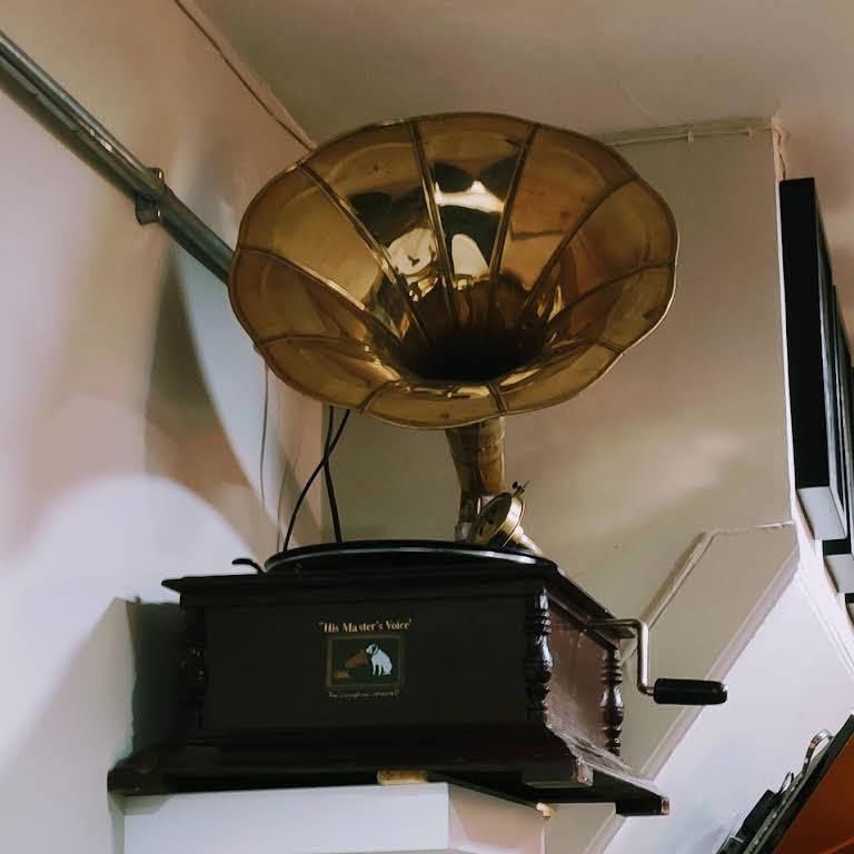 A brass-horn gramophone on a shelf